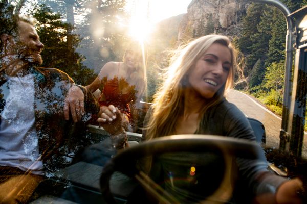 Young woman packing suitcase into car trunk for a summer road trip in Albania